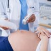 Pregnant woman receiving a ultrasound scan on the stomach in hospital